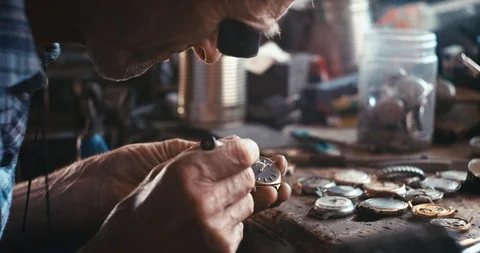The old watchmaker is repairing the vintage hand watch in his workshop. RED Stock Footage 93141732