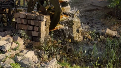 An old water mill rotated by the flow of water. Splashes flying around. Video stock 142314145