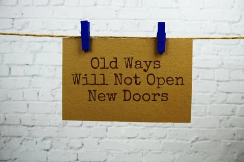 Old ways witll not open new doors text on paper card hanging with rope on w.. Stock Photos