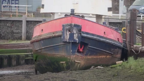 Old Weathered Barge Docked on Muddy ground at Low Tide Stock Footage 313920105