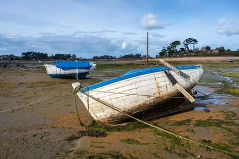 Old weathered boat beached on tidal flats in Tregastel, France Foto stock