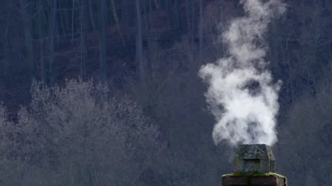 Old weathered brick and stone chimney smoking near forest Stock Footage 238527082