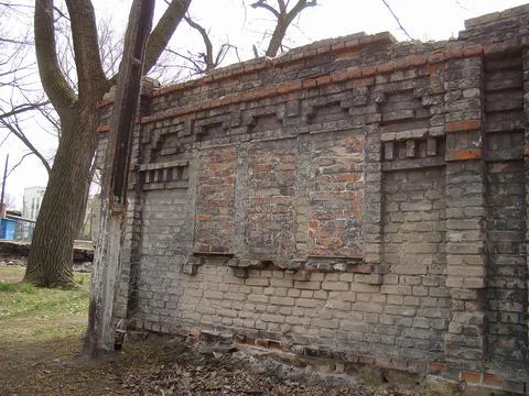 An old, weathered brick wall with missing sections and natural lighting, su.. Stock Photos