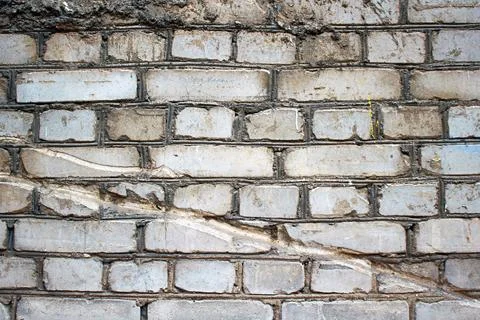 Old weathered brick wall texture with cracks and irregular surface patterns Stock Photos
