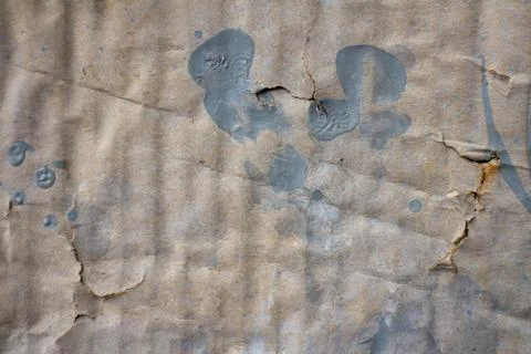 Old weathered cardboard texture with grey paint stains and rips Stock Photos