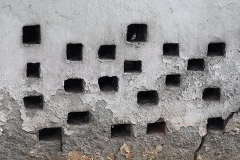 Old weathered concrete wall with square ventilation holes and rustic textur.. Stock Photos