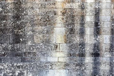 Old weathered wall made of grey bricks. Stock Photos