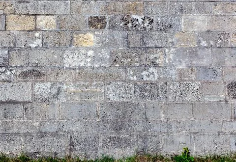 Old weathered wall made of grey bricks. Stock-Fotos
