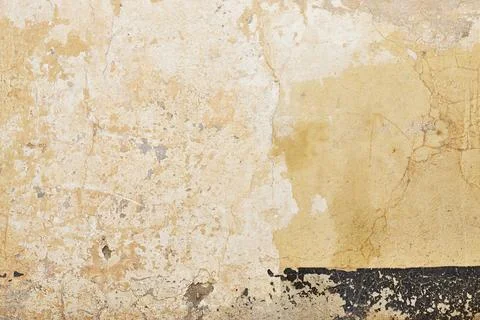 Old Weathered Wall Texture With Peeling Plaster And A Dark Baseboard Along The B Stock Photos