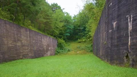 Old weathered walls frame a grassy trail leading to the forest. Видео 305107977