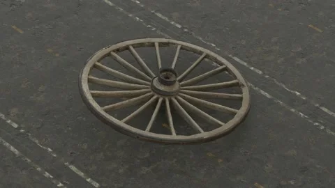 The old wheel falls on the road, but continues to rotate without stopping. A Stock Footage 148289217