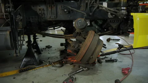 Old Wheel hub on the track, Various devices and semi truck in a repair shop Stock Footage 297023076