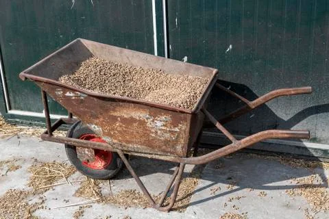 Old wheelbarrow with feed. Stock Photos