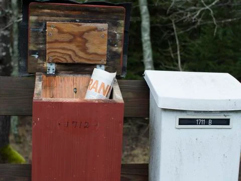 Old white and red mailboxes in the one of them Stock Photos