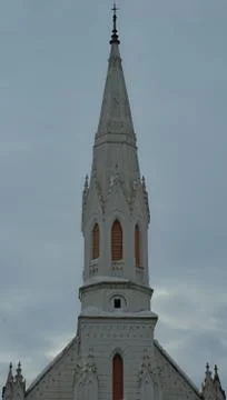 Old white bell tower of a protestant church against cloudy sky Stock Photos