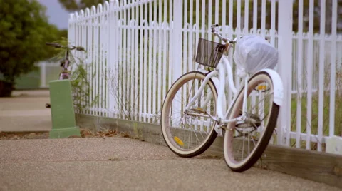 Old White Bicycle Standing Beside Fence - Color Graded 4K Resolution Stock Footage 59854121