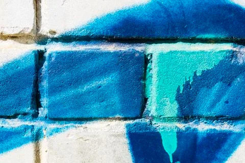 Old white brick wall with blue turquoise graffiti for background. The texture of Stock Photos