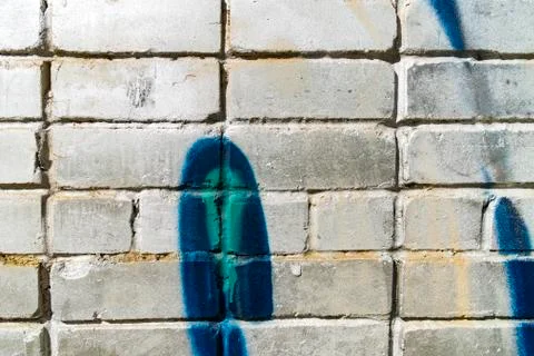 Оld white brick wall with blue green graffiti for background. The texture of a Stock Photos