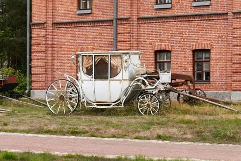 Old white carriage on the background of a red brick building Stock Photos