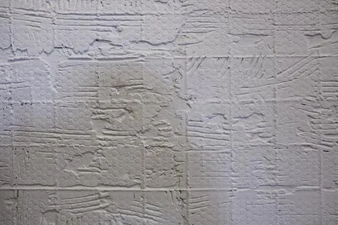 Old white damaged wall with tile prints. rough surface texture Foto stock