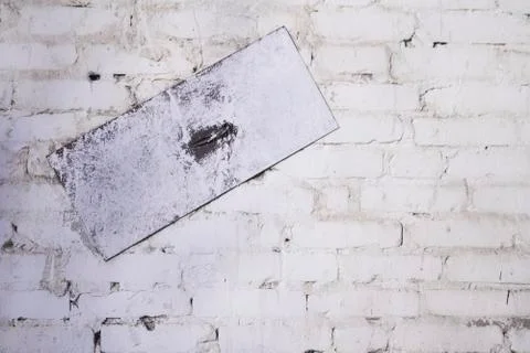 Old white-gray texture wall, brick wall background with metal plate, selectiv Stock Photos