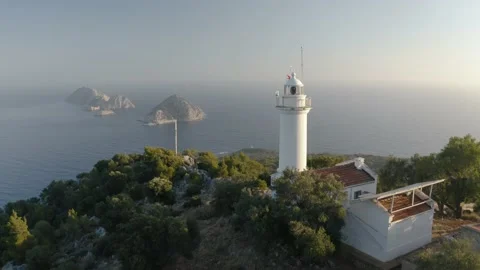 An old white lighthouse facing the islands. Mediterranian sea. Drone footage 4K. Stock Footage 133074958