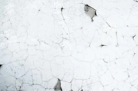 Old white paint on wall. Surface texture with cracked peeling paint. Stock Photos