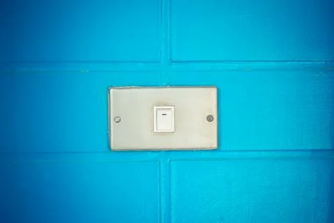 Old white switch on the bue wall Stock Photos