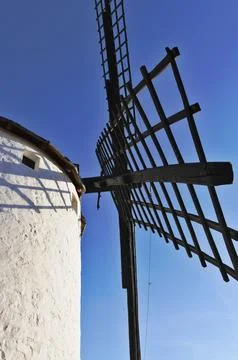 Old white windmill structure against blue sky Stock Photos