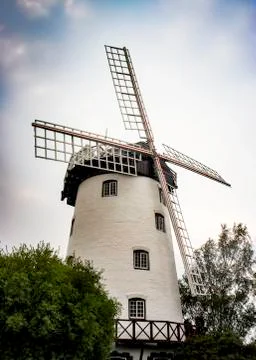 Old white windmill tower on a cloudy day Stock Photos