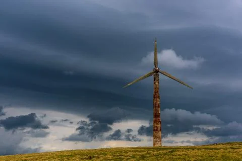 Old wind generator aeolian in the mountains with stormy clouds Foto stock