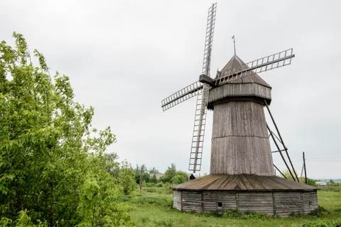 Old wind mill at the park with gray sky clouds Stock Photos