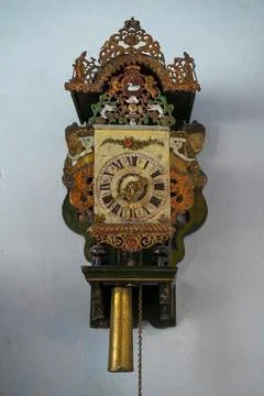Old winding clock on the wall in retro style close-up. Stock Photos