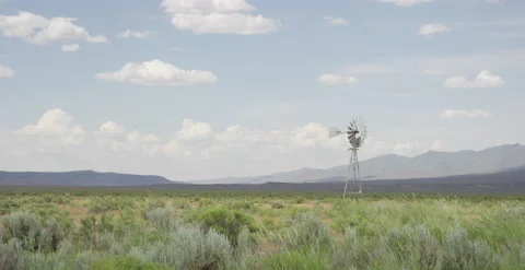 Old Windmill in Desert with Mountains Behind and Clouds 2 - 6K Slow motion Stock Footage 144010302