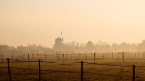 An old windmill in the mist of an early morning during winter in Germany Stock Footage