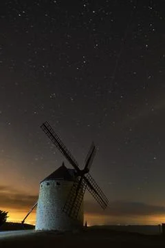 An old windmill in the night with clouds Stock Photos