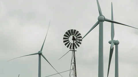Old windmill operating in front of disabled modern wind turbines. Stock Footage 87879165
