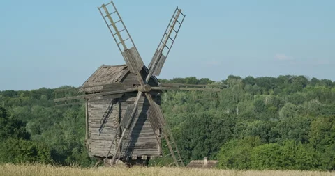 Old windmill stands in field, green trees, forest. Pirogovo Museum, Kiev Vídeos de archivo 247925388