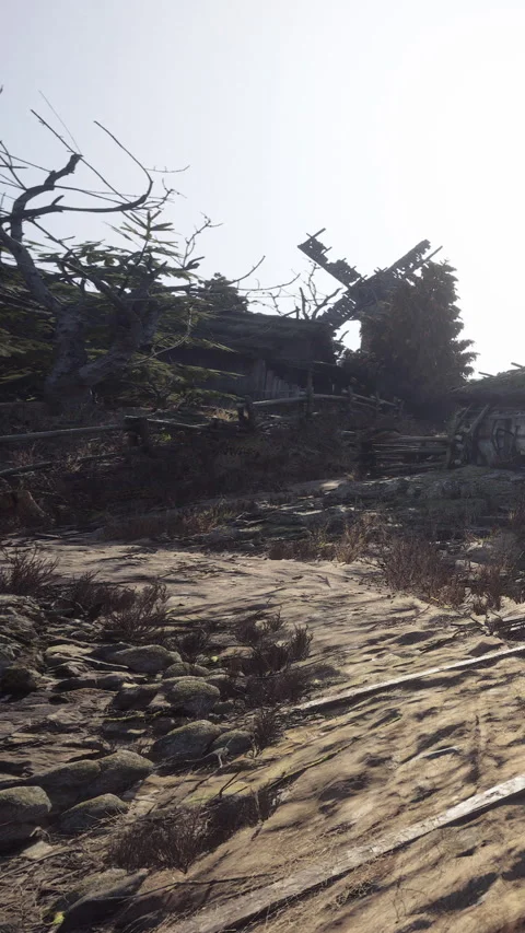 Old windmill stands next to an abandoned building on a rocky path Stock Footage 341032625