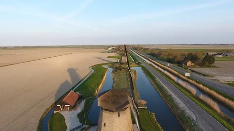 Old windmills shot by a drone that is moving backwards and up resulting in a gre 動画素材 128385308