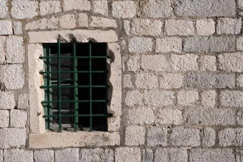 Old window with bars, in an ancient medieval wall Stock Photos