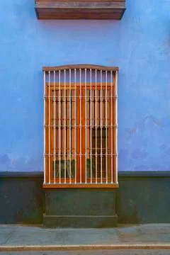 Old window with bars on a colorful facade Stock Photos