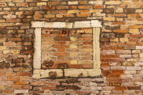 Old window frame in venice with brick stones filling the frame at a historic  Stock Photos