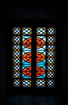 An old window with mosaics, multicolored glasses of red, blue, yellow Stock Photos
