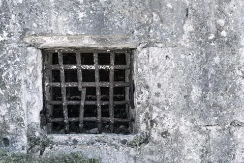Old window with a rusty lattice on ancient wall Stock Photos