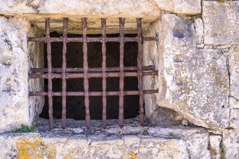 Old window with a rusty lattice on stone wall Stock Photos