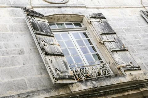 A old window with shutters is open in Cognac France, letting in some light Stock Photos