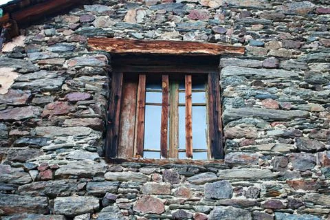 On the old window of the stone building for security, vertical wooden slats a Stock Photos