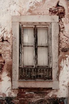 Old window in very old wall with stonework and broken plaster in Tavira, Po.. Stock Photos