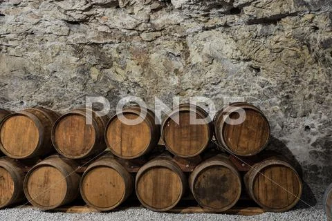An old wine cellar with oak barrels full of red wine Stock Photos